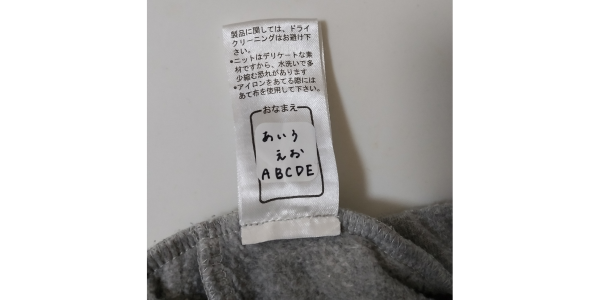 「洗濯できるタグ用お名前ラベル」を洗濯、外干しした後の画像。洋服タグに張り付いている。