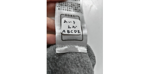 「洗濯できるタグ用お名前ラベル」の洗濯後の様子。文字は滲むことも薄まることもないが、角が浮いている。