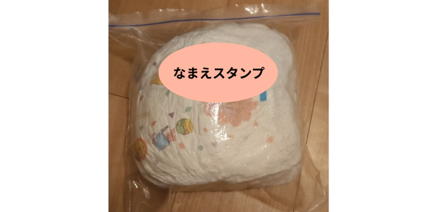おむつ10枚を入れた袋の写真。袋には見やすいところに「おむつポン」で名前を押している。